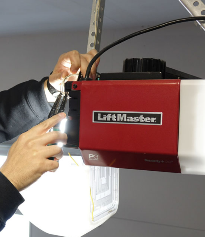 Technician performing garage door opener installation in Sarasota, FL.