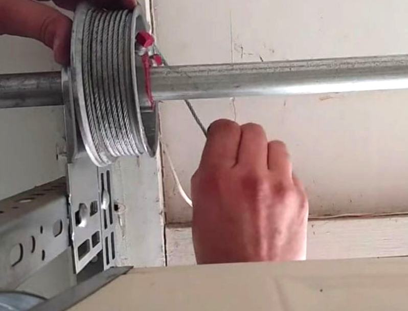 Professional technician performing garage door cable repair in Sarasota, FL, using precision tools and safety equipment.