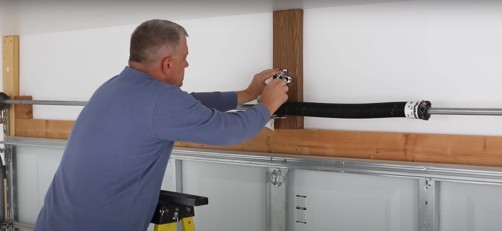 technician repairing garage door spring.